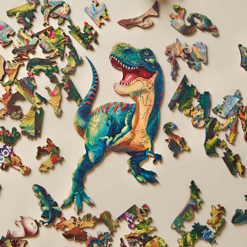 Tyrannosaurus Rex wooden dinosaur puzzle for kids — hand holding wooden puzzle piece detail