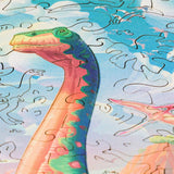 Diplodocus wooden dinosaur puzzle for kids — hand holding wooden puzzle piece detail